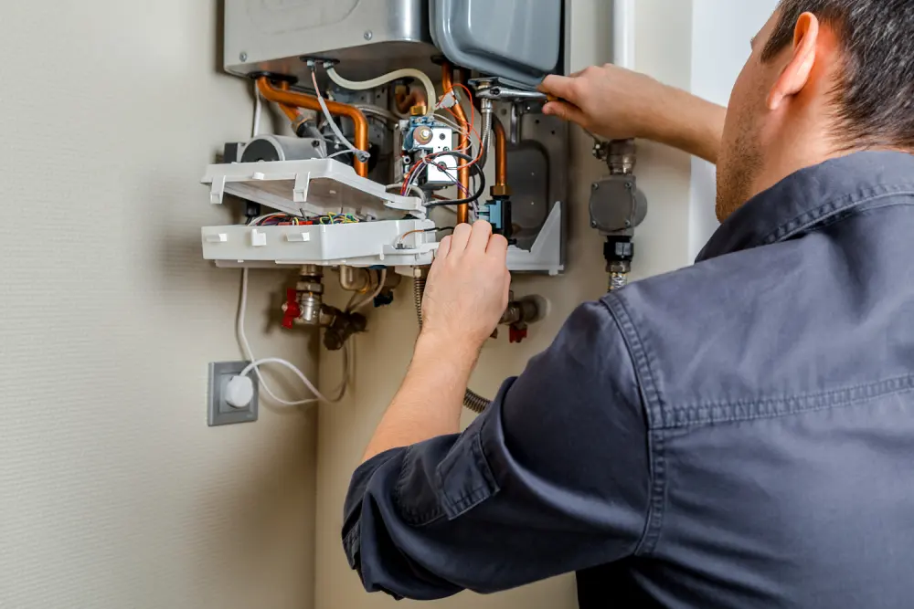 Engineer repairing an open wall-mounted boiler